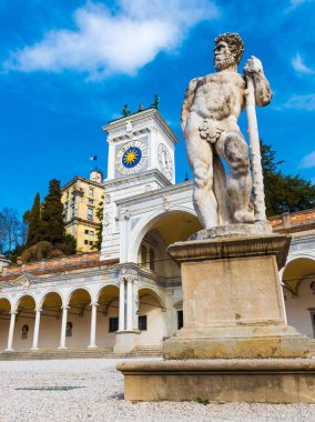 Udine merkezi kare üzerinde antik heykel. Saat Kulesi ve tarihi bina (Aziz Giovanni sundurma) eski şehir merkezinde. Friuli Venezia Giulia bölgesi, İtalya.