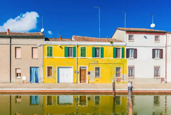 Casas de colores reflejadas en el agua. La antigua calle de Comacchio, una pequeña ciudad en la provincia de Ferrara (Emilia Romaña), también conocida como "La Pequeña Venecia" " —  Fotos de Stock