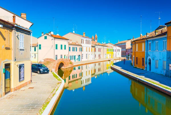 Comacchio - oktober 2016, Emilia Romagna, Italien: Utsikt över kanalen med bro och färgade hus återspeglas i vattnet. Italienska staden av Comacchio även känd som ”Lilla Venedig" — Stockfoto