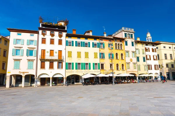 Udine - febrero 2017, Italia: Vista de la plaza central de Udine (Piazza San Giacomo). Casas residenciales de colores en el estilo de arquitectura tradicional contra el cielo azul claro — Foto de Stock