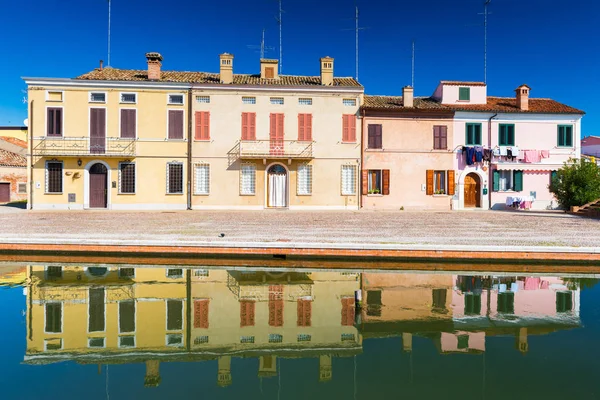 Comacchio, Emilia Romagna, Italië: Gekleurde huizen spiegel gereflecteerd in het water — Stockfoto