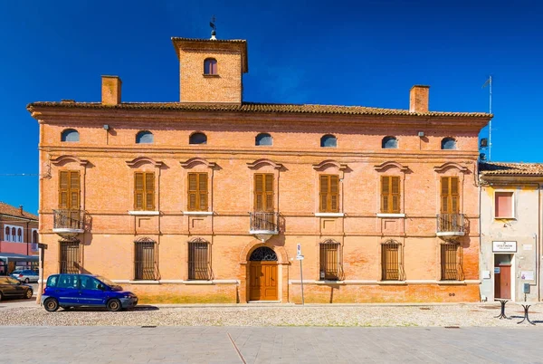 Comacchio, Italy: View of the old historical building made of red brick in the historic center of Comacchio. Blue car parked near the old building — Stock Photo, Image