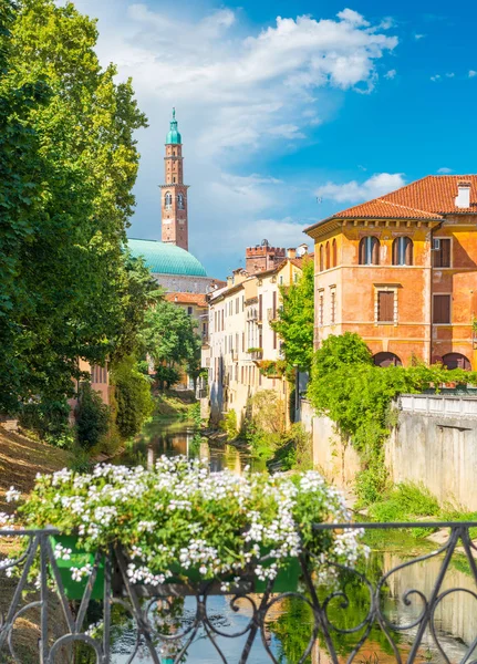 Vicenza, Italia: Vista de la antigua arquitectura histórica, el río Bacchiglione, casas residenciales y valla decorada con flores — Foto de Stock