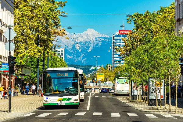 Ljubljana - Eylül 2019, Slovenya: Toplu taşımacılık, yaya geçidi, modern mimari ve arka planda karlı Alpler bulunan bir sokak manzarası