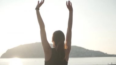 Gün batımında elini uzatan bir kız. Yavaş çekim.