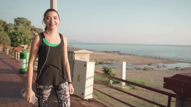 Chica caminando por el paseo marítimo después de los deportes . — Vídeos de Stock
