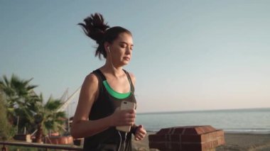 Gün batımında rıhtımda koşuyor. Deniz kıyısını yöneten kız.. 