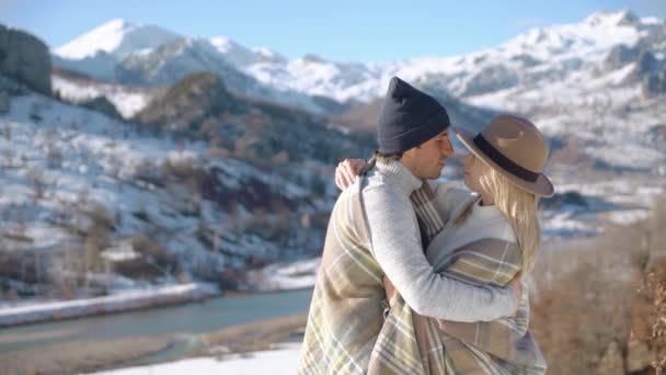 Pareja joven abrazándose con hermosas montañas nevadas en el fondo . — Vídeos de Stock