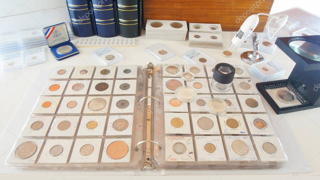 Round magnifying glass on album with coins from different countries - Numismatic scene