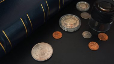 Büyüteç ve albüm için paralar - Nümismatik sahne ile siyah tabloda farklı Amerikan paralar