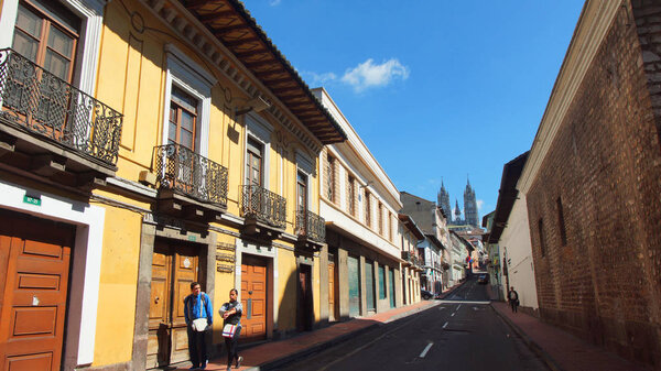 Кито, Пичинча / Эквадор - 22 января 2016: Пара прогулок в историческом центре Кито с базиликой национального обета на заднем плане
