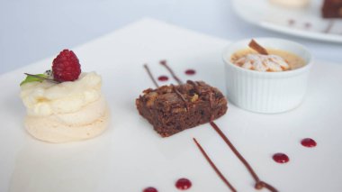 Beyaz seramik kare tabak beyaz masada üç farklı dekore edilmiş tatlılar servis