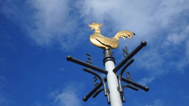 Horoz şeklin üzerindeki mavi gökyüzü arka plan bulutlar ile ile bronz vane