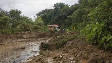 Yolu tıkayan heyelanın önünde bekleyen bir otobüsün yolcuları