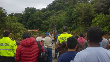 Yükleyici - ağır ekipman makinesi - yolu tıkayan bir heyelan temizlerken insanlar yolda yolculuk etmeyi bekliyor