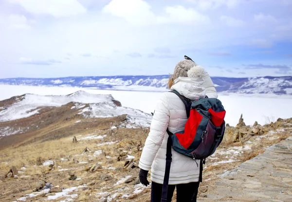 Koncepcja podróży. Kobiece turysta z plecaka enjoing widok jeziora Bajkał, Syberii, w Rosji. Turystyka zimowa. — Zdjęcie stockowe