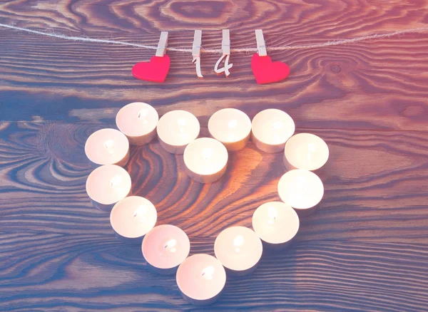 Valentine\'s day. Heart of candles. Red wooden hearts with pins a