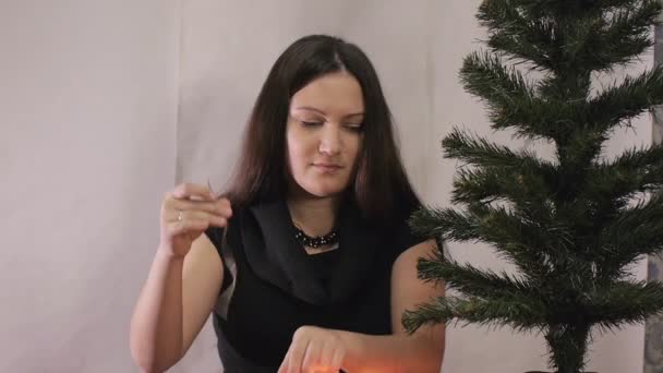 Πρωτοχρονιά, η γυναίκα των Χριστουγέννων στολίζει ένα χριστουγεννιάτικο δέντρο. — Αρχείο Βίντεο