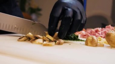 Şampiyon mantarlarını büyük bir bıçakla büyük bir kesme tahtasıyla dilimlemek