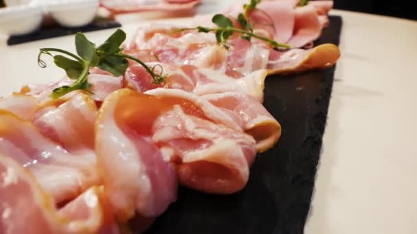 Cortar salchichas y tocino en una tabla de piedra antes de servir el primer plano — Vídeo de stock