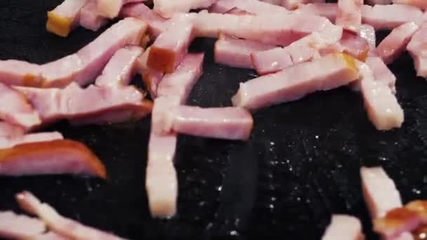 El jamón finamente picado se fríe en aceite caliente en una sartén . — Vídeos de Stock