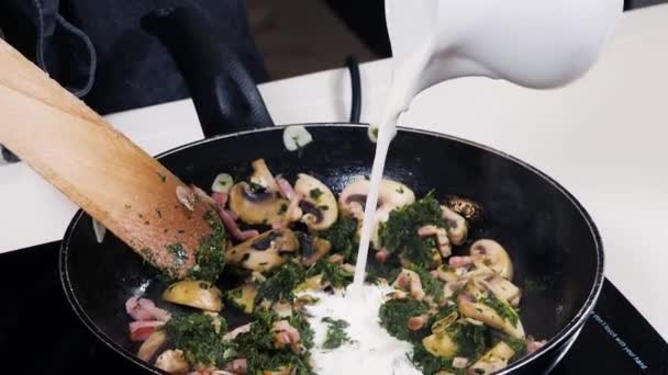 У тушкованих інгредієнтах: гриби, шпинат і часник заливають молоком — стокове відео