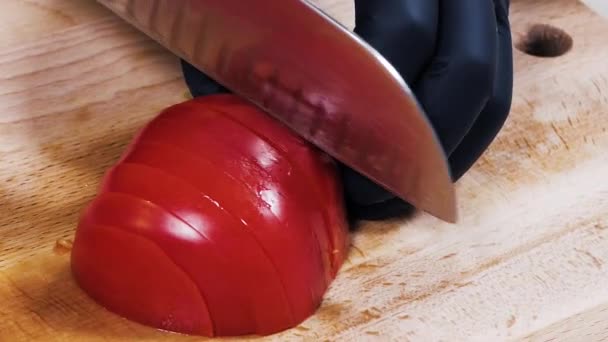 Corte de tomates em uma tábua de corte. Close-up. Movimento lento. Concentra-te. Mãos femininas cortam o tomate em fatias . — Vídeo de Stock