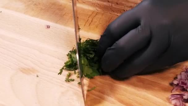 Cortar perejil fresco en una tabla de cortar grande con un cuchillo grande — Vídeo de stock