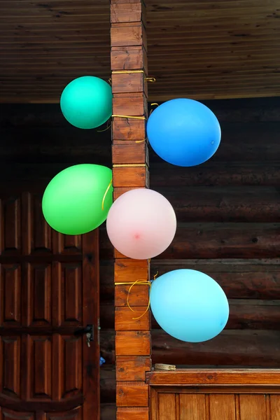 Πολύχρωμα μπαλόνια σε μια ξύλινη βεράντα του ένα ξύλινο σπίτι — Φωτογραφία Αρχείου