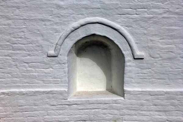 Стара біла кам'яна стіна з нішею у вигляді цегляної арки — стокове фото