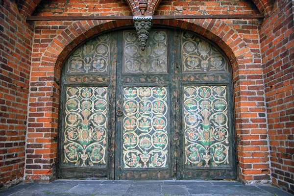 Wejście z czerwonej cegły z drzwi drewniane z kolorowe flo — Zdjęcie stockowe