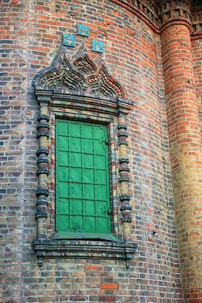Piękne okno z zielonymi okiennicami i ozdobną kamienną ramą o — Zdjęcie stockowe