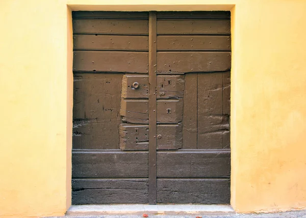 ヴィンテージ ブラウン板黄色の壁に木製のドア — ストック写真