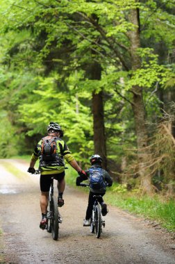 Çocuk bisikletini destekleyen eski bir bisikletçi