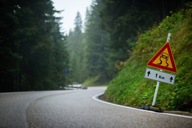 Kaygan yol işaretli kıvrımlı dağ yolu