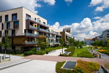 Birkaç bulut ile mavi gökyüzü altında dairelerin yeni inşa modern blok ile kamu park Görünümü