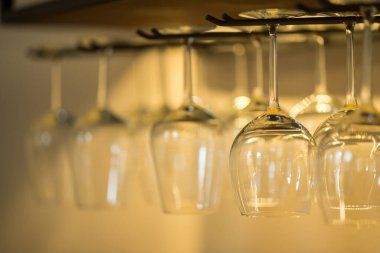 Barda asılı boş şarap kadehleri, arka planda bulanık bir fotoğraf.