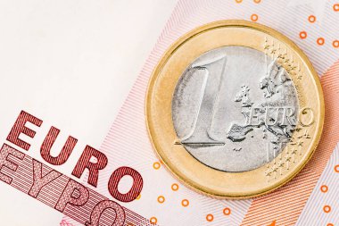 Detail of one euro coin on red banknote background clipart