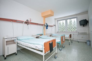 Üç yataklı boş bir hastane odası.