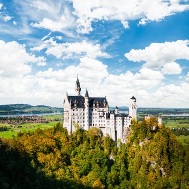Güzel manzara Neuschwanstein Şatosu (Bavyera, Almanya) sonbaharın başlarında, mavi gökyüzü ve beyaz bulutlarla