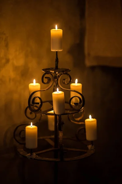 Karanlık odada mumları olan klasik bir şamdan. Eski evin romantik atmosferi.