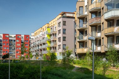 Çevresinde yeni yapılmış apartman blokları olan yeşil halk parkı