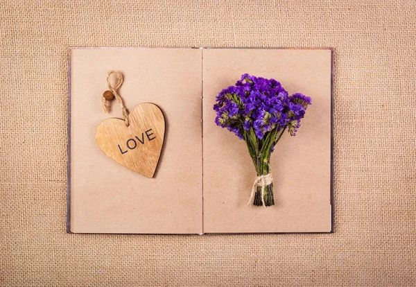 Open book, heart bookmark and flowers.