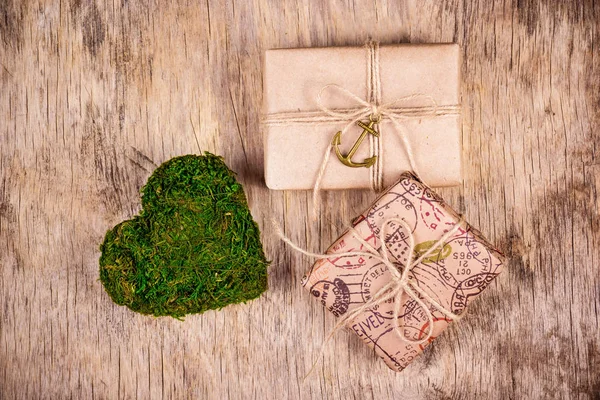 Two gift boxes and green heart made of moss. St. Valentine\'s Day. Romantic concept.