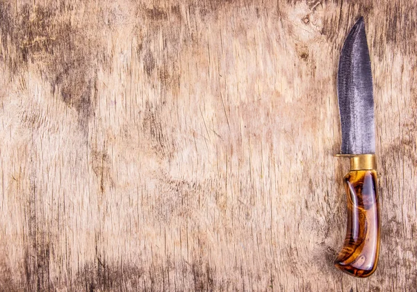 Kitchen knife with wooden handle. Wooden background and kitchen knife.