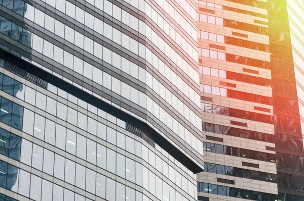 Modern glass building business center. Skyscraper in the city. The sun\'s rays are reflected in the glass surface of the building. Bottom view.