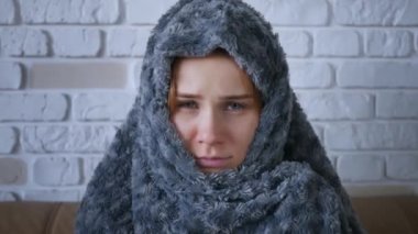 Gri, ekoseli, beyaz, donmakta olan, evinde üşüyen genç bir kadınla kaplanmış, hasta, grip hastası bir kız, içeride titreyen battaniyeye sarılı grip gribi belirtileri. Kapat.. 