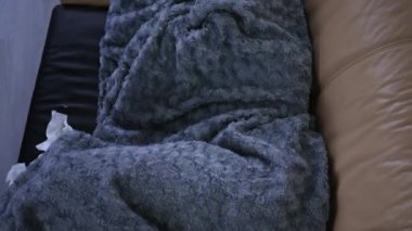 Gri, ekoseli, beyaz kadın şapkalı, eşarplı, evinde üşüyor, hasta hasta hasta bir kız, grip salgını geçiriyor, evde titreyen battaniyeye sarılı..