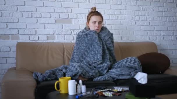 覆盖着灰蒙蒙的格子花 年轻的高加索女人冻得在家里感到冷 生病的女孩有发烧的流感病毒体温症状包裹在毛毯里 在室内发抖 — 图库视频影像