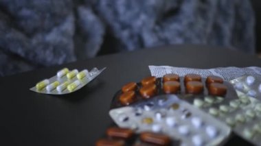 Kadın eli su toplayan torbalardan hap alıyor. Kadın elinin üzerine beyaz tablet dök. Elinde tıbbi doz hapı var. Grip, yetişkin, soğuk algınlığı, hastalık, virüs, ağır çekim hapları.
